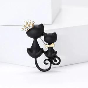 Artistic matte black double cat brooch with rhinestone crown and golden bow decoration