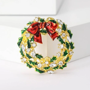 Makroaufnahme der Weihnachtskranz-Brosche mit Stechpalmenblättern und roter Schleife