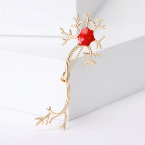 Golden neuron medical brooch with red enamel cell body on minimalist white block
