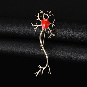 Macro detail of a golden neuron cell brooch with vibrant red enamel on a black leather base