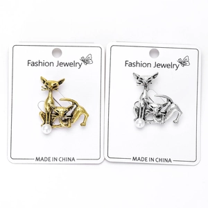 Detail view of retro alloy cat brooches in gold and silver finish with imitation pearls