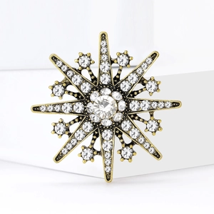 Vintage snowflake brooch in antique gold finish with sparkling crystals and a large center diamond