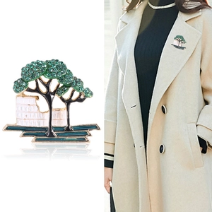 Green rhinestone tree brooch with white brick wall base and black enamel trunk detail