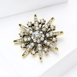Macro shot of vintage star brooch showing sparkling rhinestones and gold plating