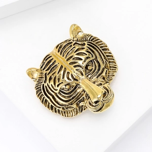 Macro detail of vintage golden tiger head brooch featuring intricate embossed textures