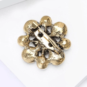 Vintage Baroque gold flower brooch with secure safety pin back on white background
