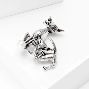 Detail view of retro silver cat brooch with playful kittens and white pearl accent