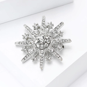 Detailed macro view of shiny silver snowflake brooch with white cubic zirconia stones