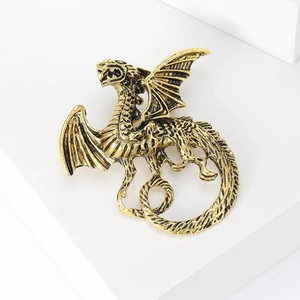 Close-up of vintage gold dragon brooch showing detailed scales and dragon wing textures