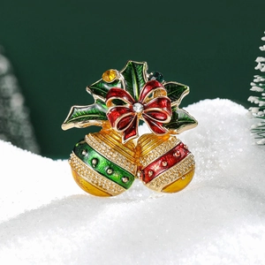 Détail de la broche de Noël avec feuille de houx et cloches émaillées dorées