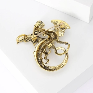 Detailed back view of a vintage golden dragon brooch showing the secure pin fastener
