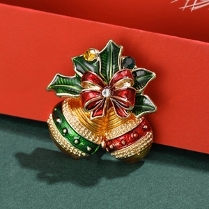 Broche cloche de Noël avec feuilles de houx sur un fond festif en velours vert foncé