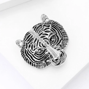 Macro shot of silver alloy tiger head brooch with vintage texture and black stripes