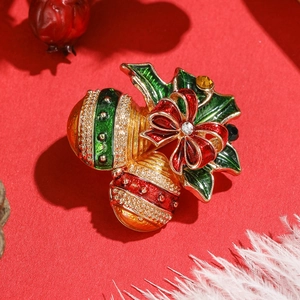 Broche cloche de Noël en émail avec nœud rouge et houx sur fond de décoration festive