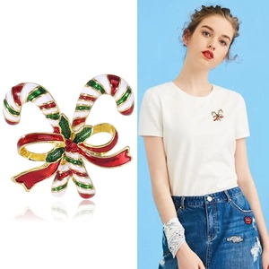 Macro detail of Christmas candy cane brooch with red bow on festive alloy metal