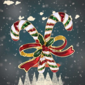 Close-up of Christmas candy cane brooch with red ribbon on a snowy background