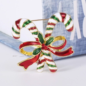 Macro shot of Christmas candy cane brooch with red bow and sparkling red crystal detail