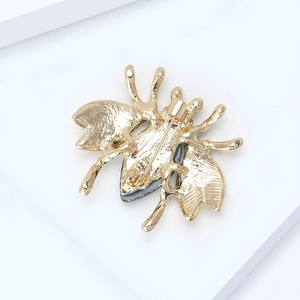 Exquisite gold-plated bee brooch back view with secure pin on white display stand
