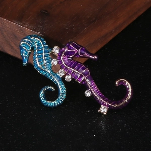 Close-up of artistic dual seahorse brooch with enamel finish and sparkling crystal accents