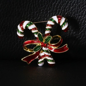 Detailed close-up of Christmas candy cane brooch with enamel bow and red rhinestone