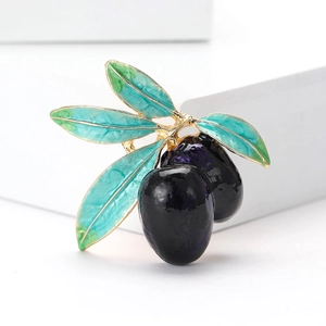 Detailed view of an olive brooch with green leaves and purple enamel on stone