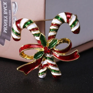 Detailed macro view of Christmas candy cane brooch with red bow and holly leaf