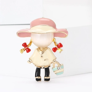 Détail de la broche en émail petite fille avec chapeau rose et sac à main en strass bleu