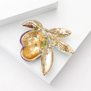 Detailed back view of enamel olive brooch with golden alloy and secure safety pin clasp