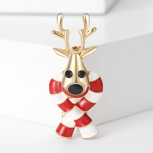 Détail d'une broche de renne de Noël avec bois dorés et écharpe en émail rouge et blanc