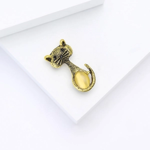 Elegante spilla a gatto in lega d'oro vintage con gemma gialla su sfondo bianco puro