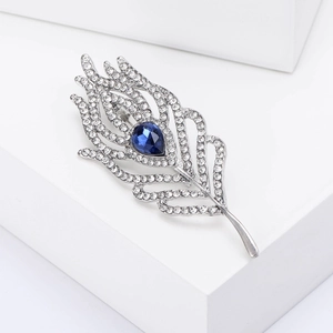 Detail of silver feather brooch with sparkling rhinestones and a blue pear-shaped gemstone