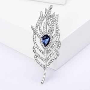 Elegant silver feather brooch with sparkling rhinestones and a blue teardrop stone