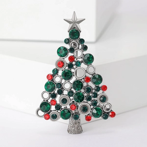 Detail of silver Christmas tree brooch with sparkling green and red rhinestones