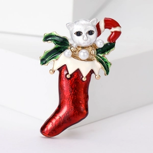 Detail of Christmas stocking brooch with white cat and pearl accents on a white block