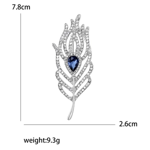 Elegant silver feather brooch with white crystals and teardrop blue gemstone pendant