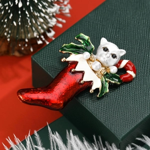 Christmas cat brooch featuring a white kitten in a red stocking with pearls and holly leaves