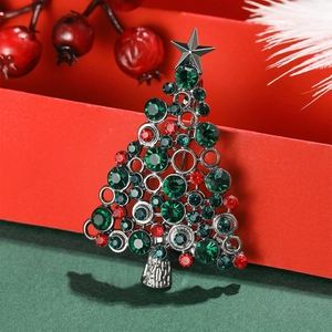 Elegant Christmas tree brooch with green and red crystals on a festive gift box