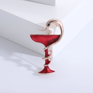 Détail de la broche serpent et calice rouge en or rose sur présentoir blanc