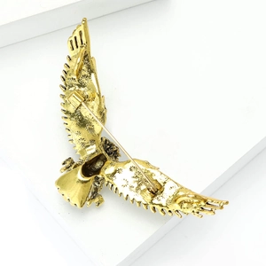 Detailed back view of golden eagle brooch showing safety pin clasp and wing textures
