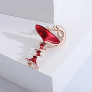 Macro d'une broche en forme de verre à cocktail avec serpent doré et émail rouge brillant