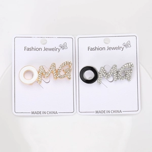 Close-up of gold and silver OMG brooches with crystal rhinestones on display cards