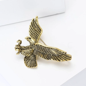Dettaglio della spilla a forma di aquila in oro vintage con piume e chiusura a spilla