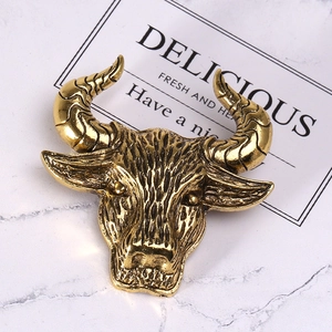 Close-up of vintage golden ox head brooch showing detailed metallic textures and carving