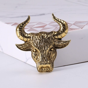 Detailed macro view of retro golden bull head brooch with carved texture and spiral horns