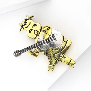 Nahaufnahme der Retro-Kuh-Gitarrenbrosche mit Gold- und Silberlegierungstextur