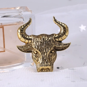 Macro view of vintage bronze bull head brooch with detailed metallic texture and engraving