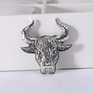 Close-up of vintage silver bull head brooch with detailed metallic texture and antique finish