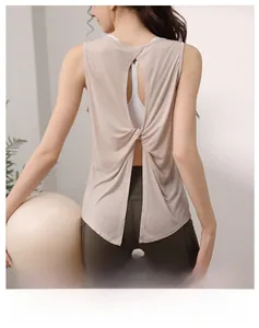 Detail of cross-knot back design on light pink yoga tank top for fitness training