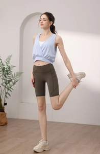 Detail showing high-waisted olive green cycling shorts with side stitching and stretch fabric