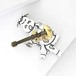 Detailaufnahme einer Vintage-Brosche in Form eines Gitarre spielenden Kalbes aus Legierung